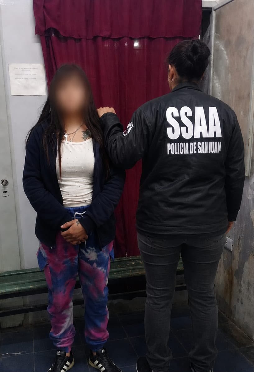 Personal policial junto a la mujer detenida durante uno de los allanamientos en Rawson