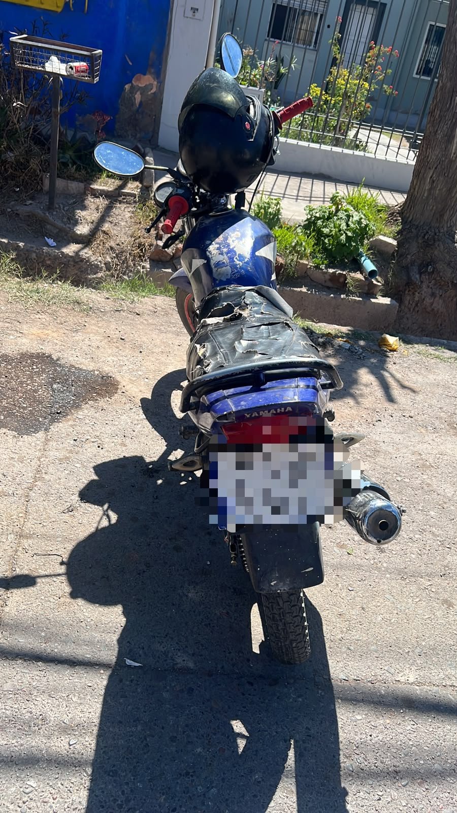 Motocicleta Yamaha azul secuestrada durante el procedimiento por el robo en barrio UTA, con la patente pixelada.