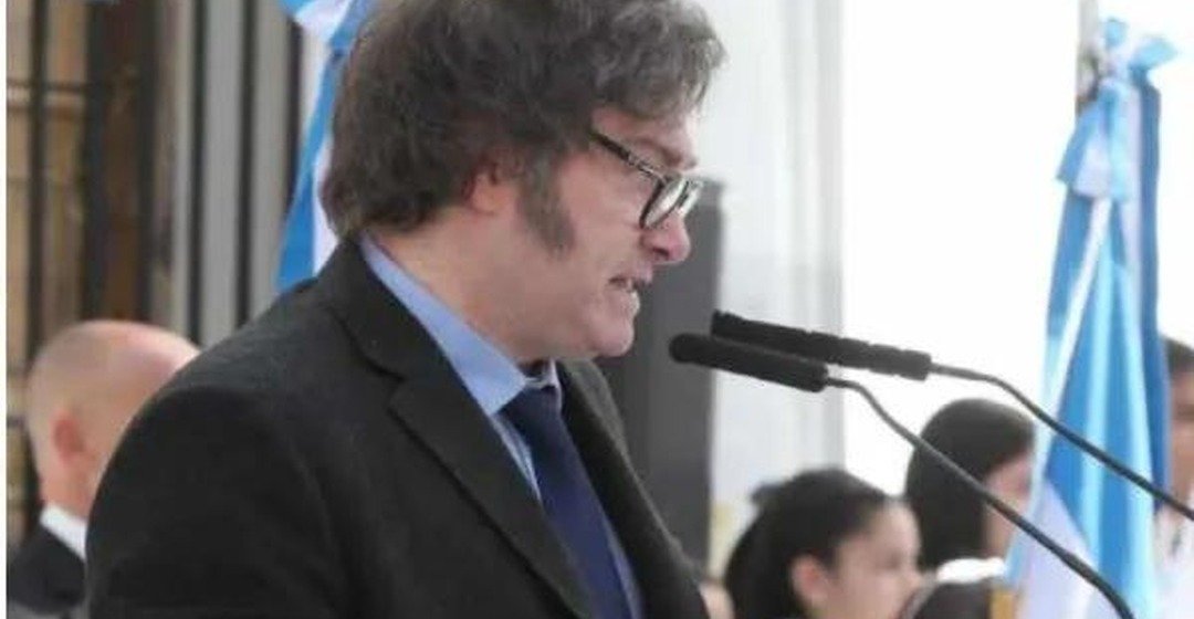 Javier Milei habla frente a un atril con micrófono durante un acto.