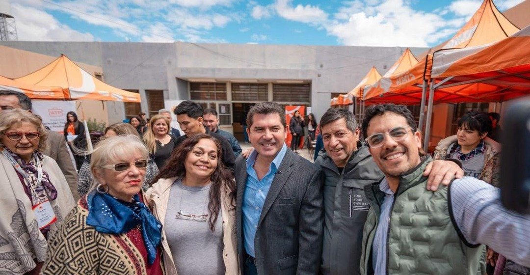El gobernador Marcelo Orrego posa con vecinas y funcionarios frente a gazebos naranjas del operativo.
