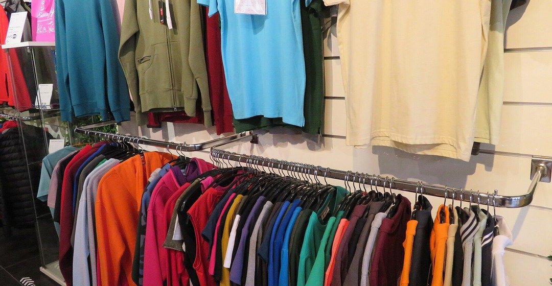 Imagen ilustrativa: percheros con ropa en un local comercial.