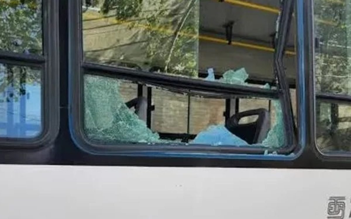 Ventanilla rota de un colectivo, con restos de vidrio en el marco.