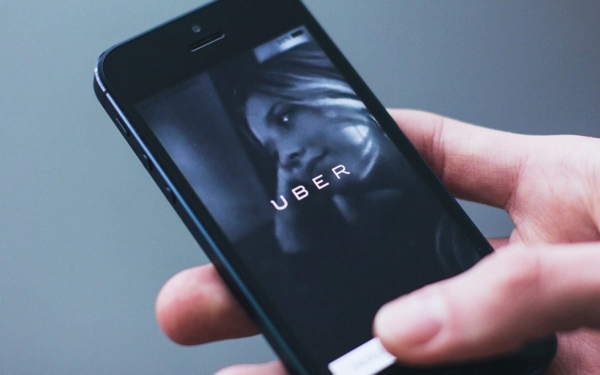 Mano que sostiene un celular con la aplicación Uber abierta en la pantalla. Imagen ilustrativa.