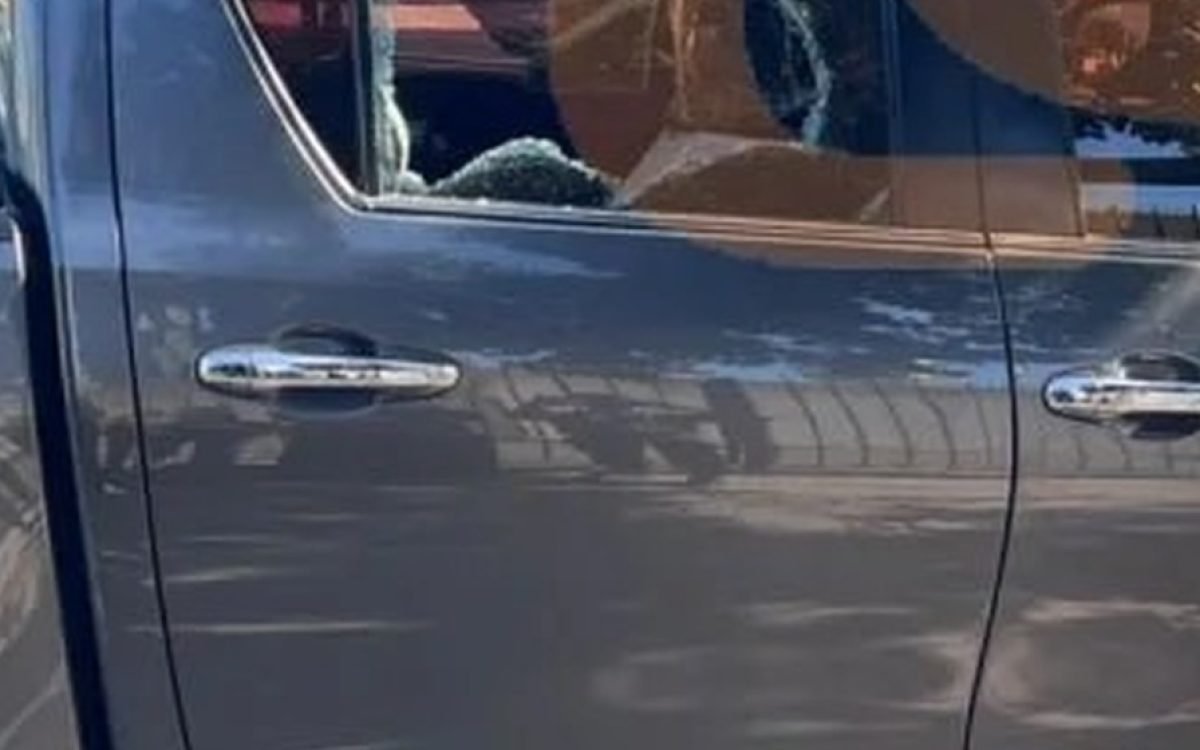 Ventanilla trasera rota de una camioneta gris, en una calle de Rawson.