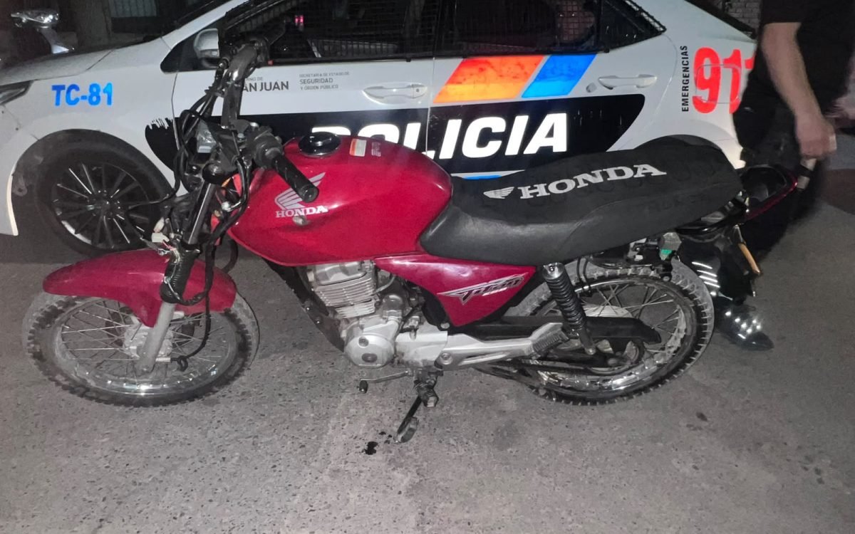 Honda CG Titan roja y mÃ³vil policial TC-81. CrÃ©dito PolicÃ­a de San Juan.
