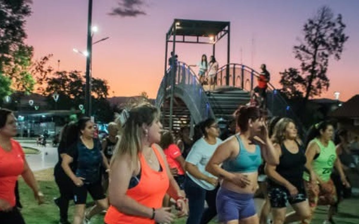 Mujeres hacen zumba en un parque de Rawson al atardecer.