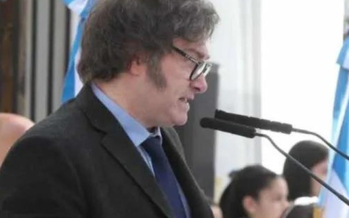 Javier Milei habla frente a un atril con micrófono durante un acto.