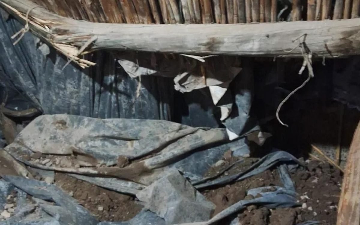 Escombros, tierra y cañas del techo caído dentro de una vivienda de Villa San Damián, en Rawson.
