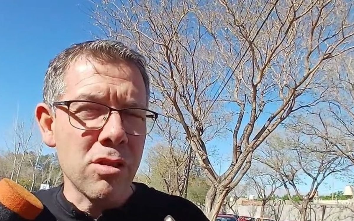 Darío Molina, hasta ahora subsecretario de Servicios de Rawson, habla ante micrófonos en una calle arbolada.